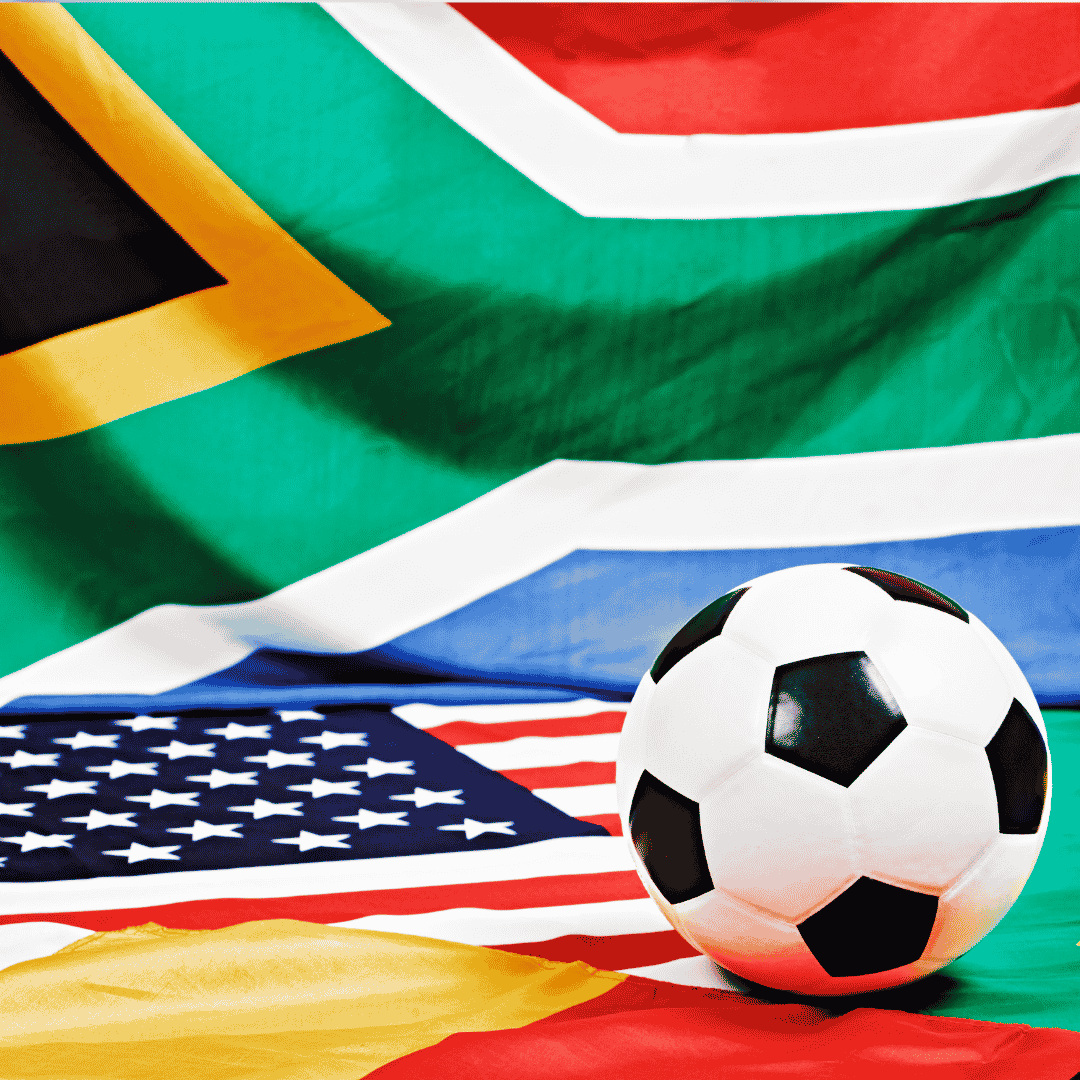 A soccer ball sits on top of an American flag, with the South African flag—famously represented by Lloyd Madurai—and part of another flag in the background.